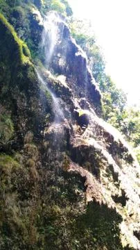 Waterfall and the rays of the sun Stock Photos