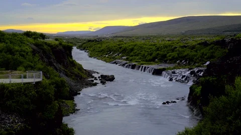 Waterfall and river flowing through mossy landscape during sunset Stock Footage 73011503