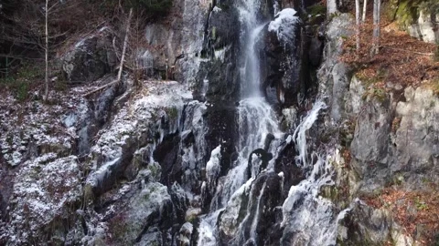Waterfall and river flowing through a snowy and frozen mountain landscape. Stock Footage 326794698
