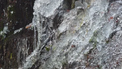 Waterfall and river flowing through a snowy and frozen mountain landscape. Stock Footage 326794727