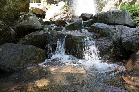 Waterfall and stream bed view between rocks Stock Photos