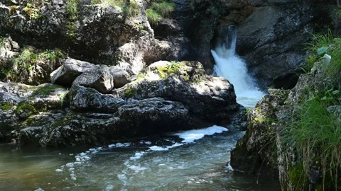 A waterfall and a stream lie between beautiful rocks in the mountains Stock Footage 219382521