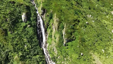 Waterfall and winding path on a green Andermatt hillside 스톡 동영상 348190284