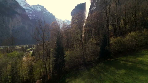 Waterfall appearing behind trees, then long fly up surrounding fall - Aerial 4K Stock Footage 220897281