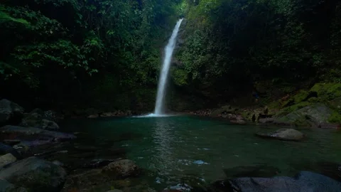 Waterfall cascades into a calm, turquoise pool. Vídeos de archivo 334628374