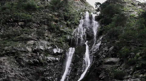 Waterfall cascades down a cliff face Stock Footage 29573461