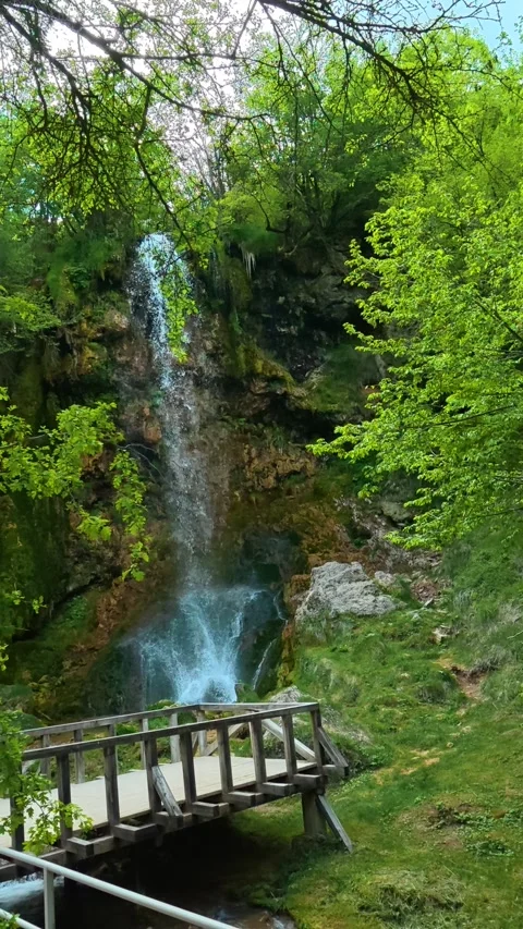 Waterfall cascades down mossy cliff face. Gostilje, Serbia. Vertical Stock Footage 337061893