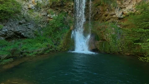 Waterfall cascades into a tranquil, deep green pool. Veliki Buk, Serbia. Stock Footage 336888966