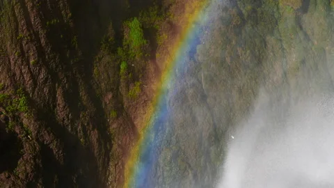 Waterfall cascading down the mountain creating rainbow 動画素材 148026975