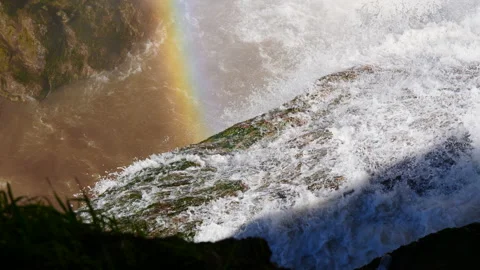 Waterfall cascading down the mountain creating rainbow 2 Stock Footage 148042888
