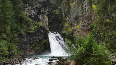 Waterfall cascading down mountainside in forest Video stock 283323381