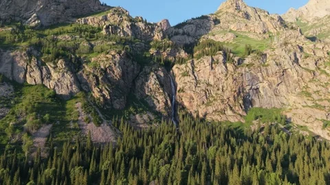 Waterfall cascading down mountainside into lush valley 動画素材 312446122