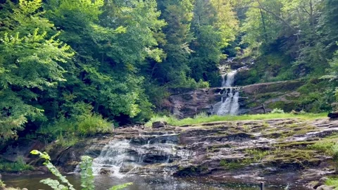Waterfall Cascading Down Rock Ledges in Forest Wide Shot Stock Footage 344812029