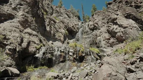 Waterfall cascading down a rocky cliff in Colorado mountains Video stock 348022544