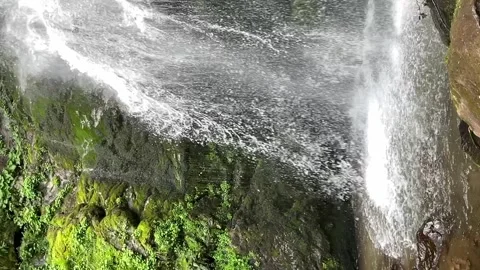 Waterfall cascading down rocky cliffs, water stream falls from above from a.. Stock Footage 244049692