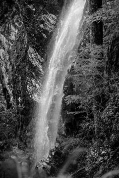 Waterfall cascading down rocky cliffs in forest Stock Photos