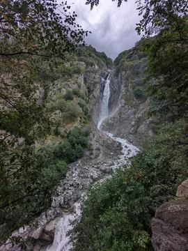 Waterfall cascading down rocky cliffs surrounded by lush greenery Fotos de archivo