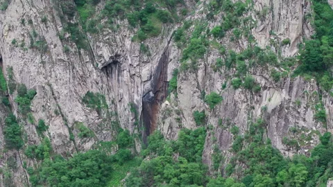 Waterfall cascading down rocky mountain cliff 스톡 동영상 289640573