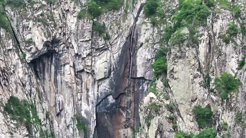 Waterfall cascading down a rocky mountain cliff Stock Footage 289670567