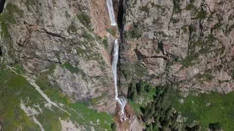 Waterfall cascading down rocky mountainside in scenic landscape Stock-Footage 312437925