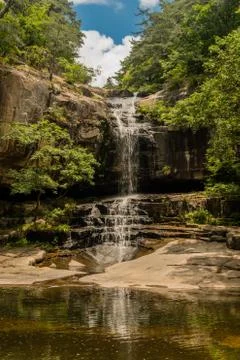 Waterfall cascading down rocky mountainside. Stock Photos