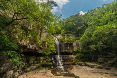 Waterfall cascading down rocky mountainside. Stock Photos