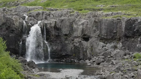 Waterfall Cascading Down Rugged Basalt Cliffs in Iceland 4K Nature Footage Stock Footage 339736675
