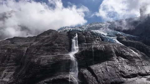 Waterfall cascading from a glacier down a mountain Stock Footage 318197823