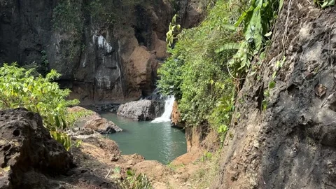 Waterfall Cascading into Natural Pool in Lush Tropical Jungle, Focus Pull Shot Stock Footage 324769203