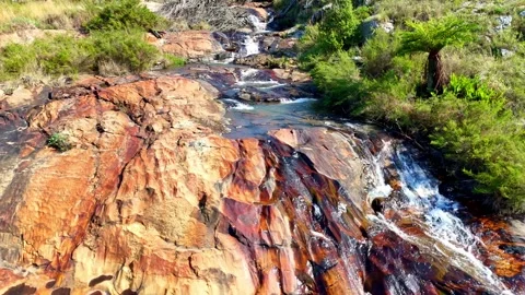 Waterfall cascading over colorful rocks Video stock 296542286