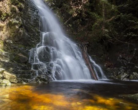 Waterfall cascading over rocks creates a serene atmosphere in a forest sett.. Stock Photos