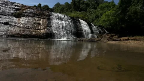 Waterfall Cascading Over Rocks into Placid Pool, Green Forest, Tracking Shot Stock Footage 324772767