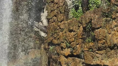 Waterfall Cascading Over Rocky Grotto at Castle Hill in Nice Vídeo Stock 344054882