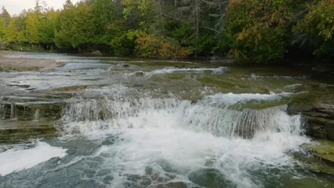 Waterfall cascading through the forest rotation aerial shot Stock Footage 256942095