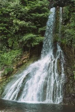 Waterfall cascading through lush forest landscape in northern Italy Stock Photos