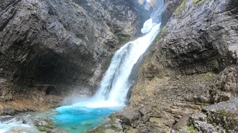 Waterfall Cascading into Turquoise Pool in Rocky Canyon Stock Footage 344033326