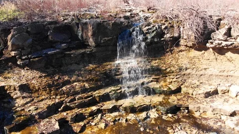 Waterfall off a cliff into a stream Stock Footage 98614682