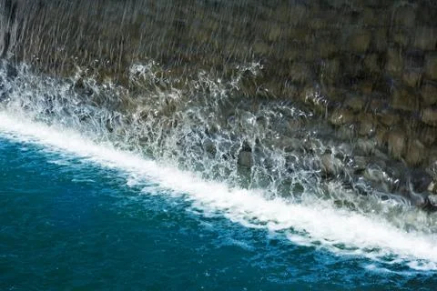 Waterfall close up image. Splashes and foam on blue water surface from fallen Stock-Fotos