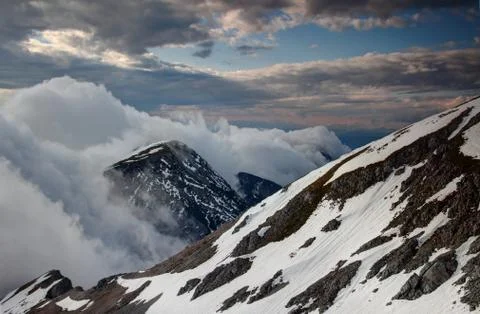 Waterfall-like clouds flowing down the steep Karavanke ridge Stock Photos