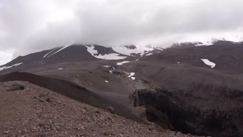 A waterfall that cut through the mountainside, in the distance the Mutnovsky vo Video stock 96516816