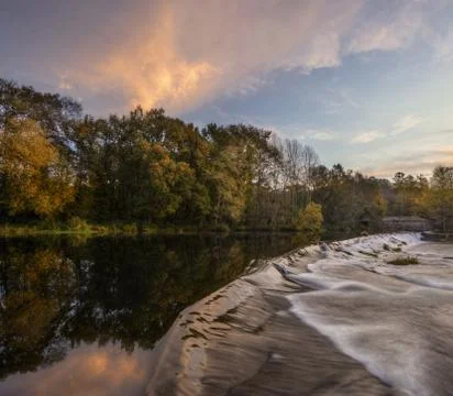 Waterfall on the dam of an old mill Stock Photos