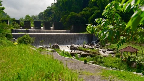 Waterfall dam river flow green beautiful green grass nature calm village Stock-Footage 265399420