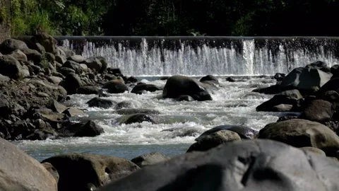 The waterfall is dammed by a river with large rocks Stock Footage 287993307