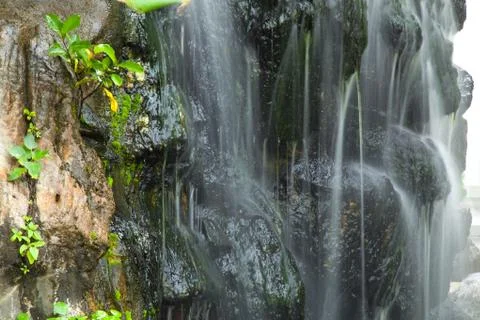 Waterfall in decorated garden Stock Photos