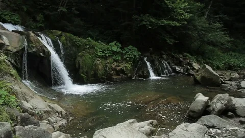 Waterfall in a deep forest green nature rock environment forest river mountains Stock Footage 99371403