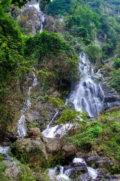 Waterfall in deep rain forest jungle Stock Photos