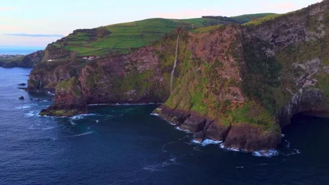 Waterfall dropping from green Azores cliffs into the ocean Stock-Footage 341327907