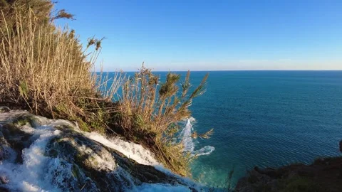 Waterfall Edge with Airplane in Sky and Boat on Mediterranean Sea Stock Footage 333445721