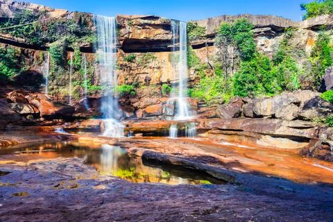 Waterfall falling from mountain top with reflection and blue sky at day from  Stock-Fotos