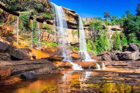 Waterfall falling from mountain top with reflection and blue sky at morning f Stock-Fotos